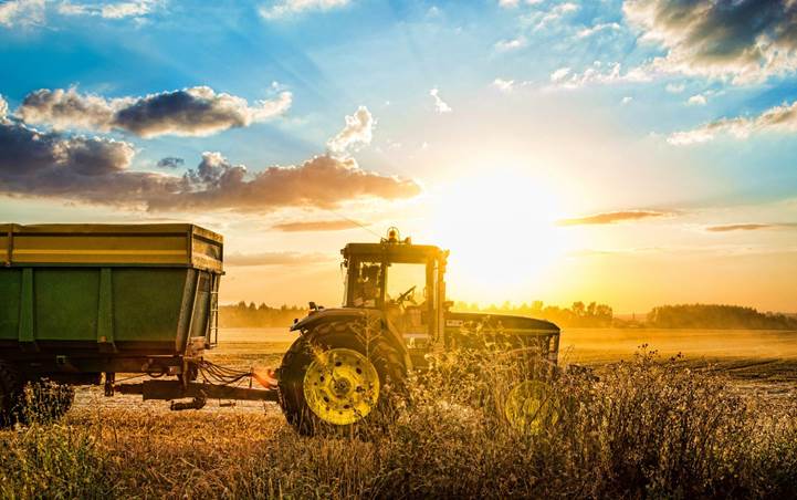 John Deere Traktor auf dem Feld bei Sonnenuntergang